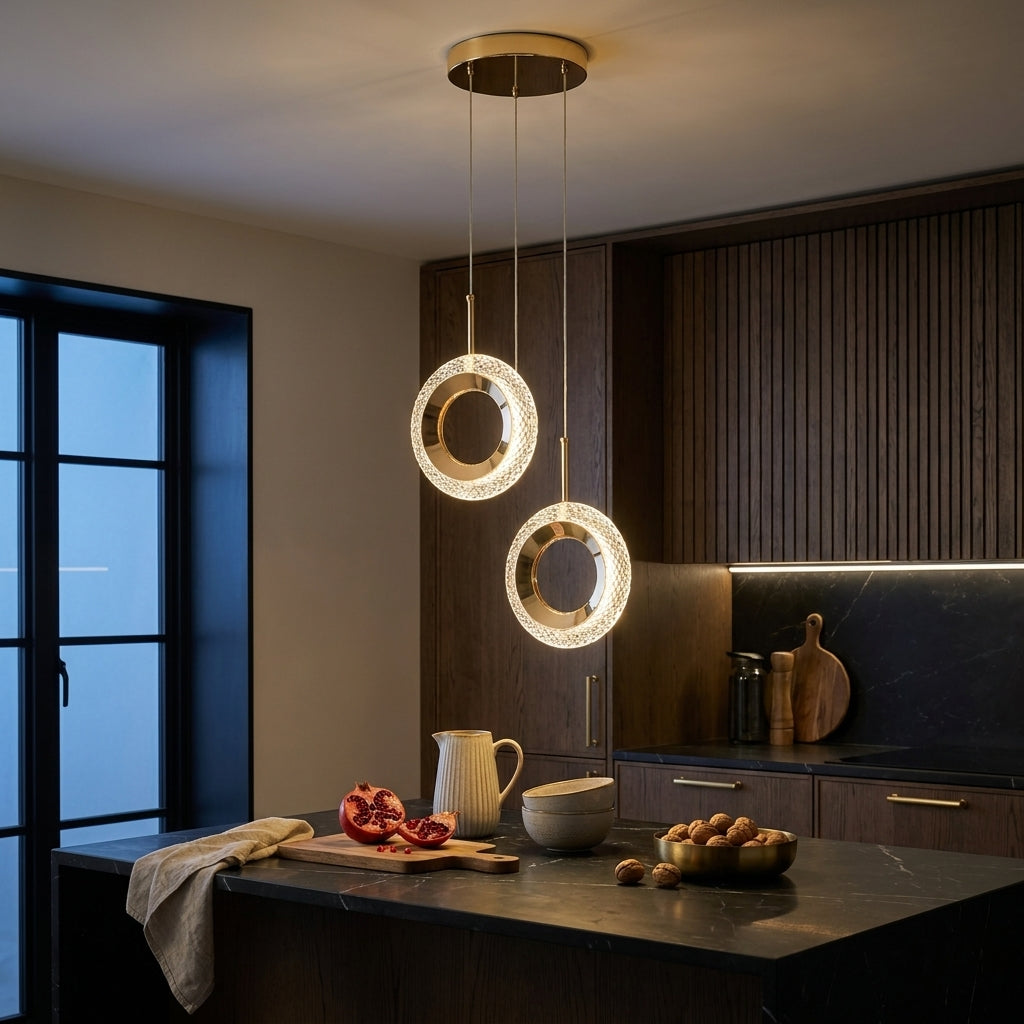 Two-head round ring crystal gold LED pendant light over a black marble kitchen island