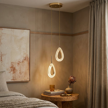 Two-head teardrop crystal gold LED pendant light beside a bedside table in a warm bedroom
