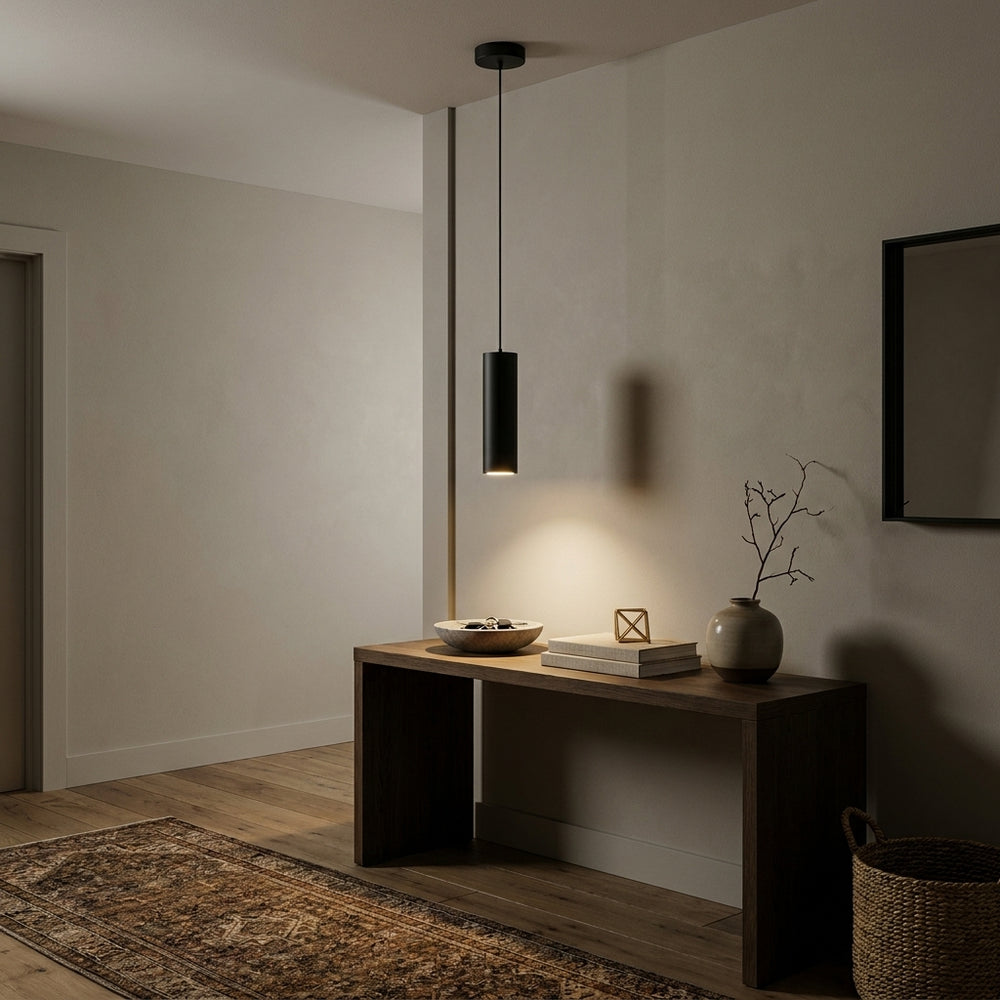 Matte black 30 cm LED cylinder pendant light with warm white light above an oak console table in a hallway