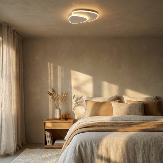 Sculptural Triangle LED Ceiling Light in warm white above a bed in a cosy quiet-luxury bedroom